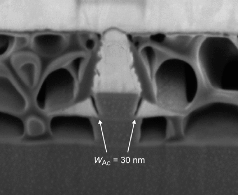 FIB cross section of a finalized transistor. The arrows mark the base access distance Formula. Voids in the Teflon planarization layer are caused by exposure to the ion- and electron-beams during inspection.